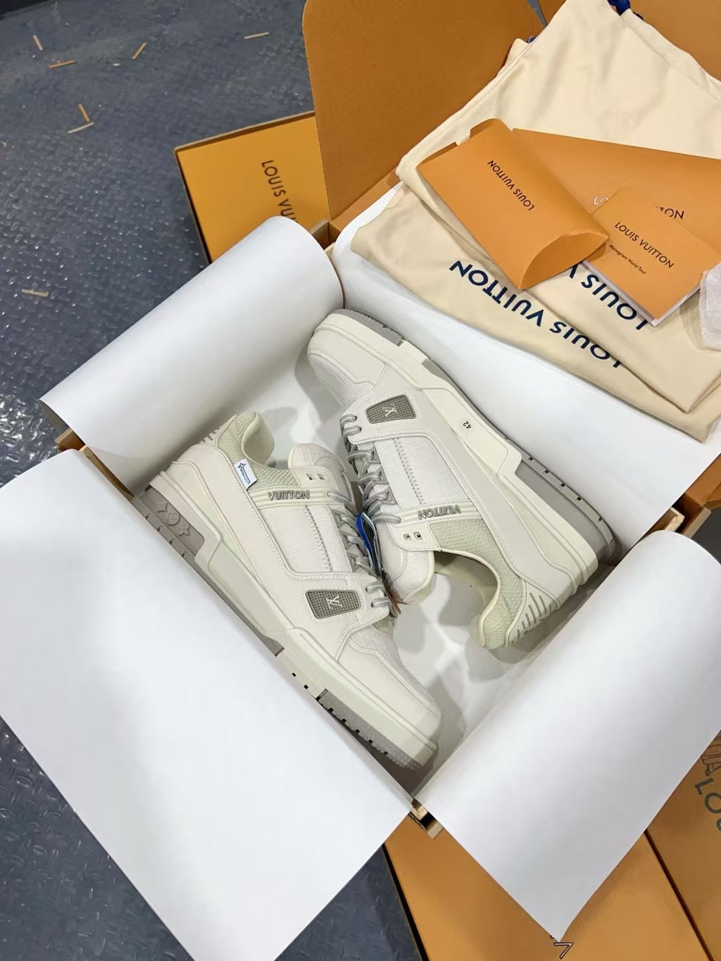 White Louis Vuitton trainer shoes, top view with embossed side panel.