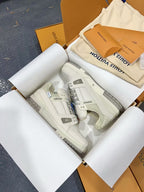 White Louis Vuitton trainer shoes, top view with embossed side panel.