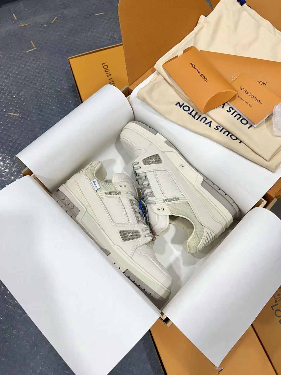 White Louis Vuitton trainer shoes, top view with embossed side panel.