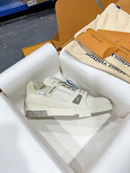 White Louis Vuitton trainer shoe, side view with LV logo and blue lace stripe.