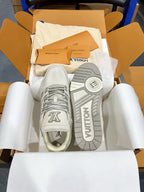 White Louis Vuitton trainer shoes, outsole view with VUITTON text.