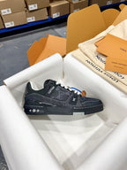 Louis Vuitton low-top sneakers on white wrapping, dark uppers with white laces and LV mark