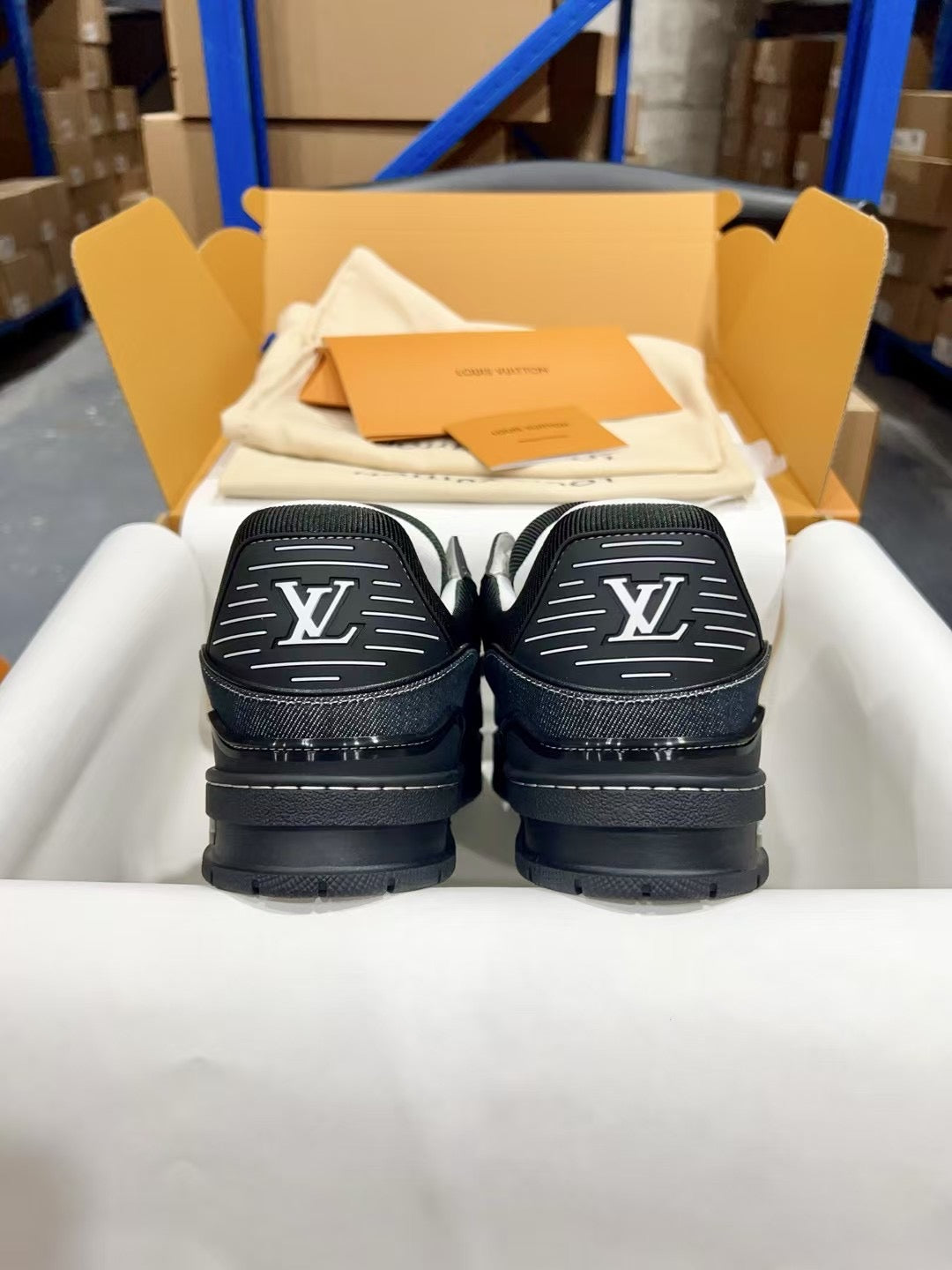 Louis Vuitton low-top sneakers back view, dark heels with large white LV monograms