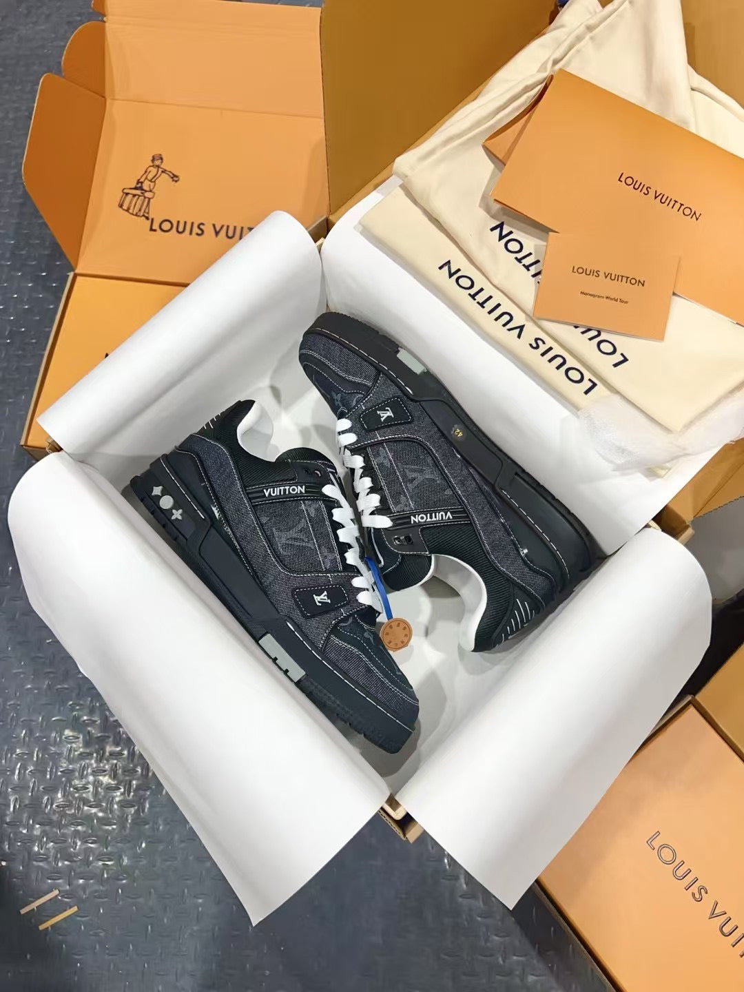 Louis Vuitton low-top sneakers shown from above in a box, dark with white laces