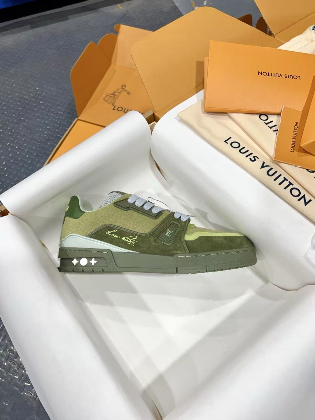 Side profile of green and olive Louis Vuitton trainer sneakers with white laces