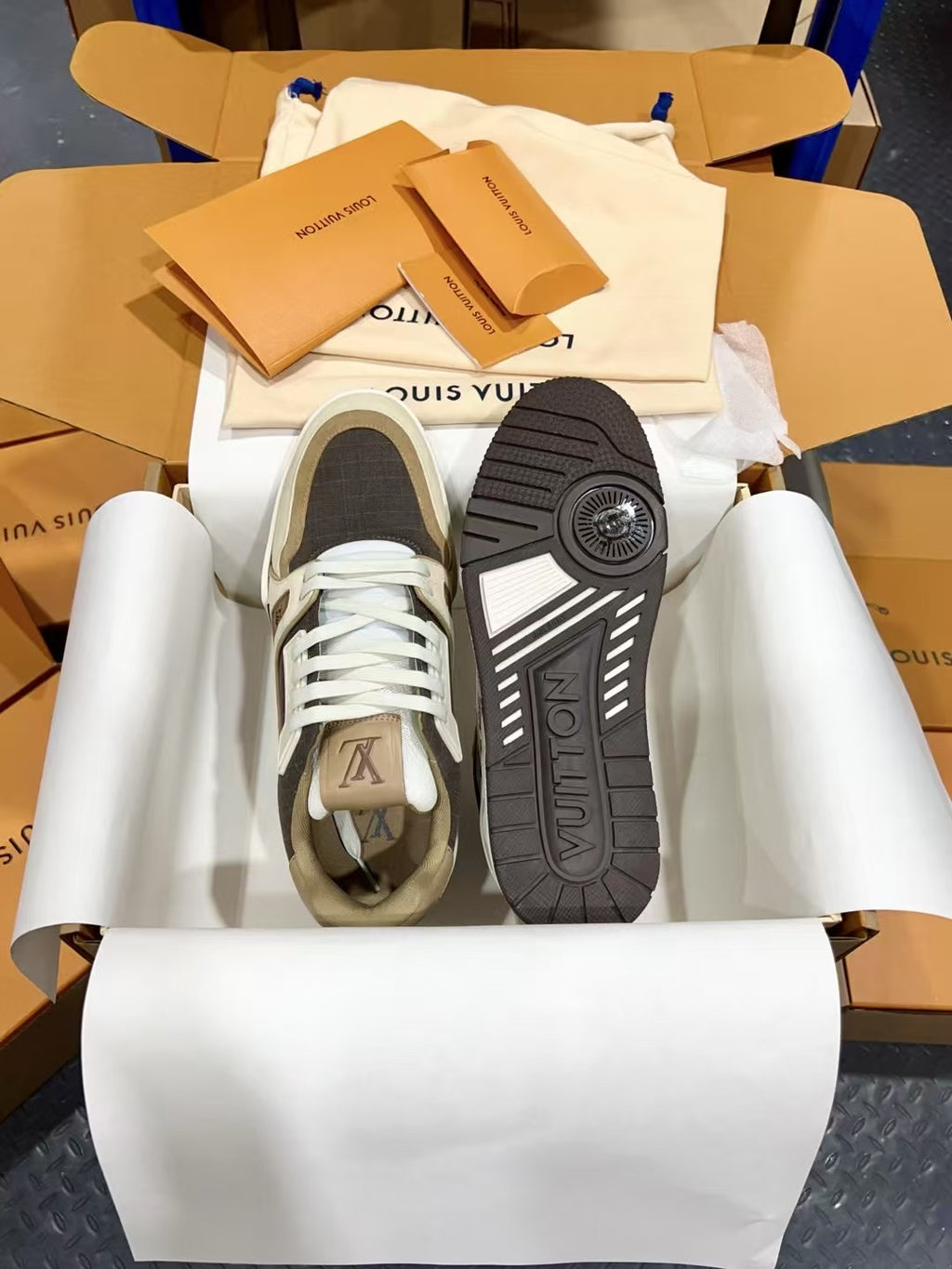 Louis Vuitton trainer sneakers with dark gray outsoles, underside view showing tread