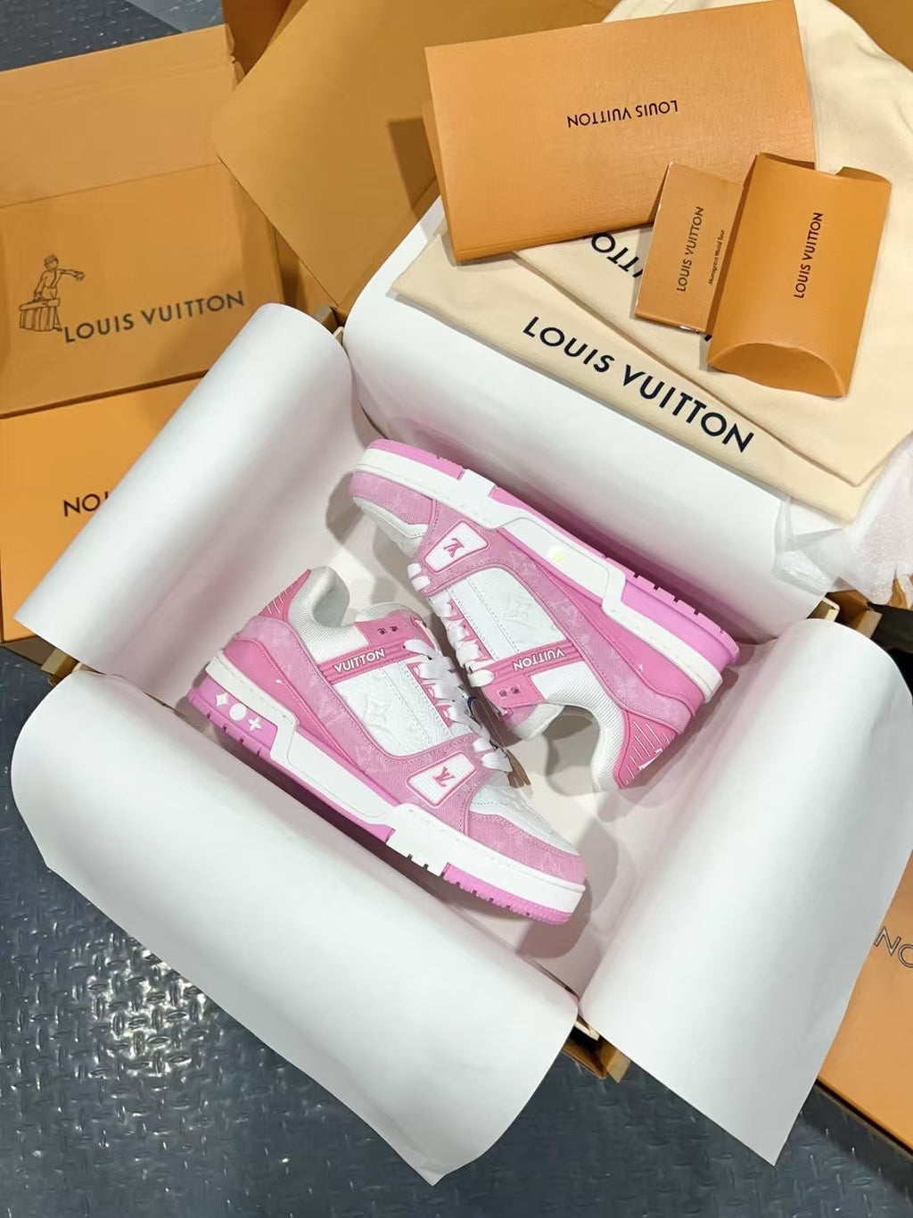 Pink and white low-top sneakers showing front and side logo panels