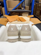 White Louis Vuitton trainer sneakers with LV logo on heel, back view in box.