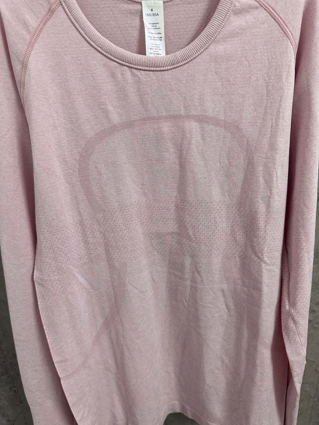 Pink long-sleeve crewneck T-shirt front, partial close-up