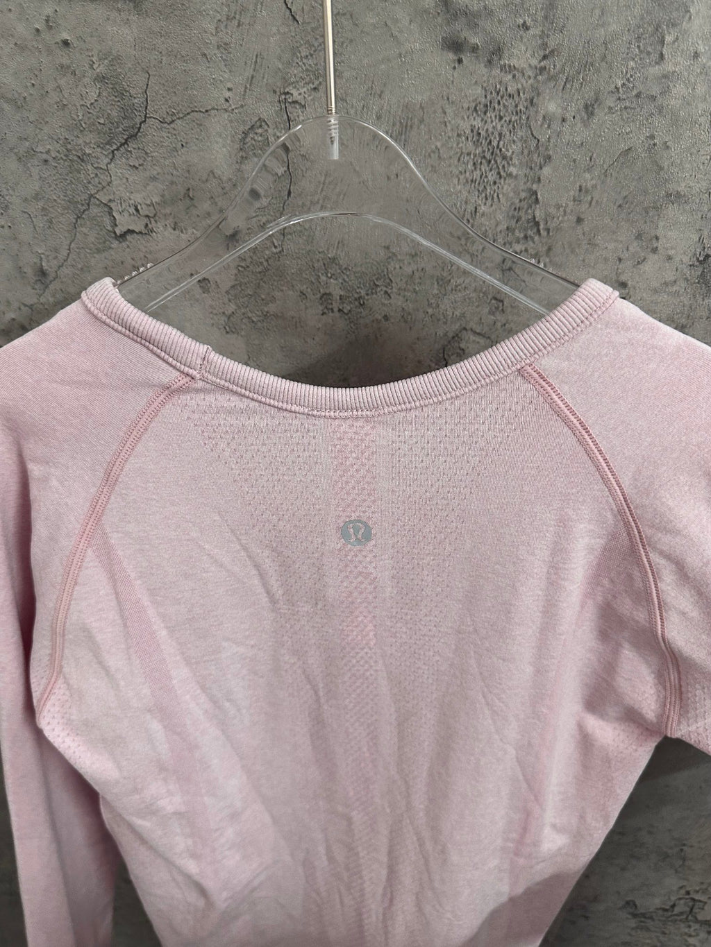 Light pink long-sleeve top with crew neckline and small back-center dot