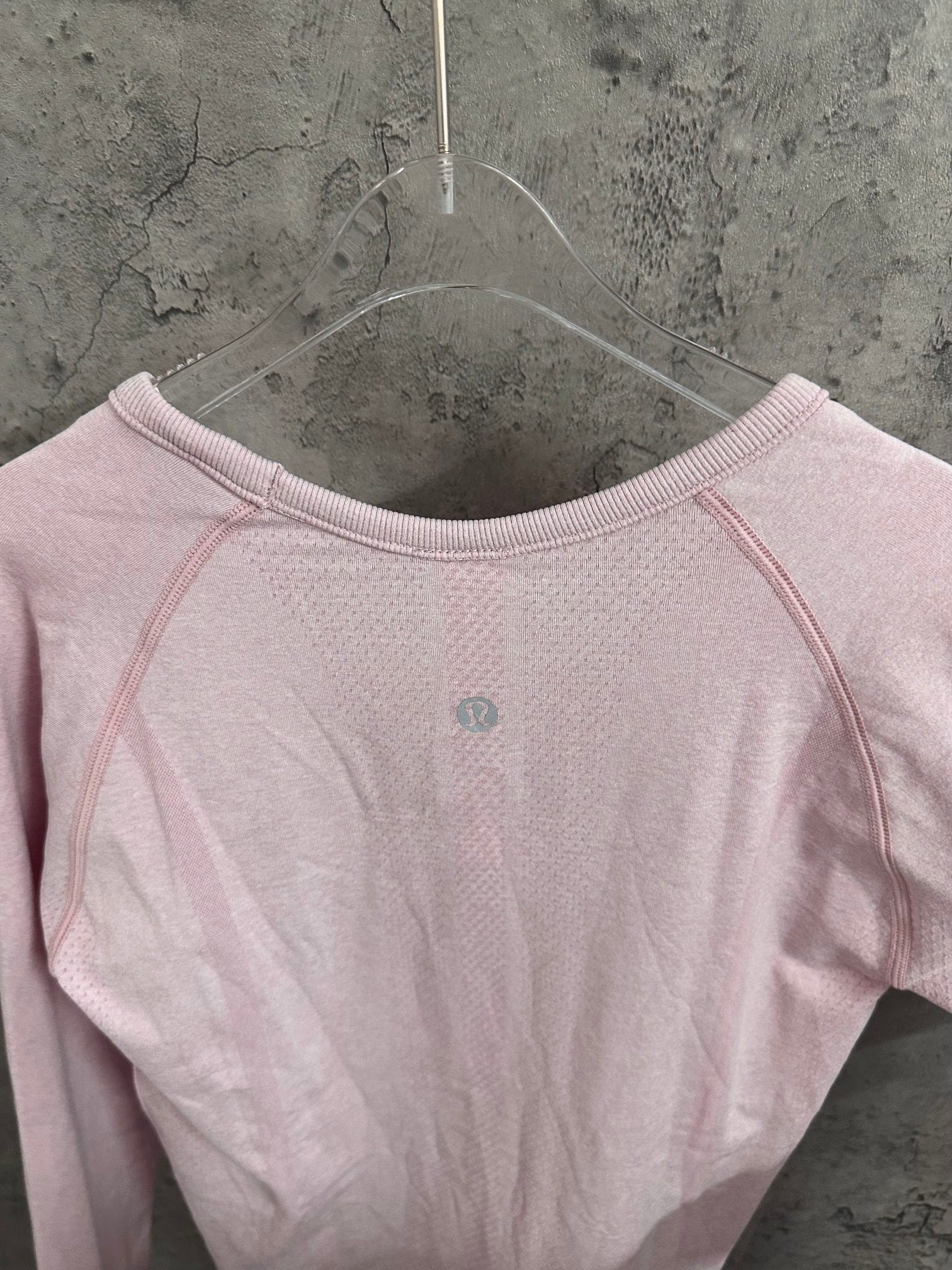 Light pink long-sleeve top with crew neckline and small back-center dot