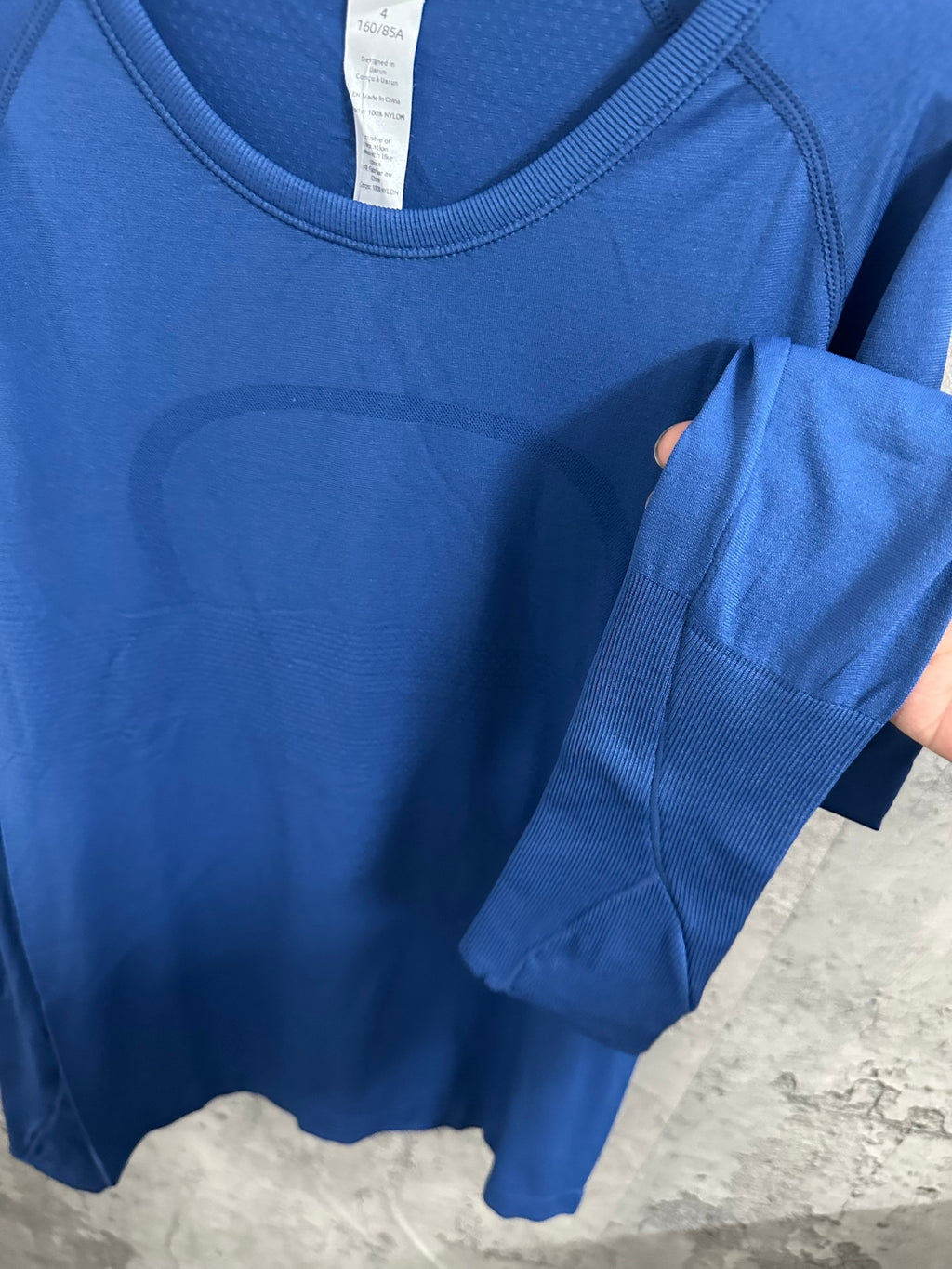 Blue long-sleeve T-shirt with side seam and ribbed cuff.