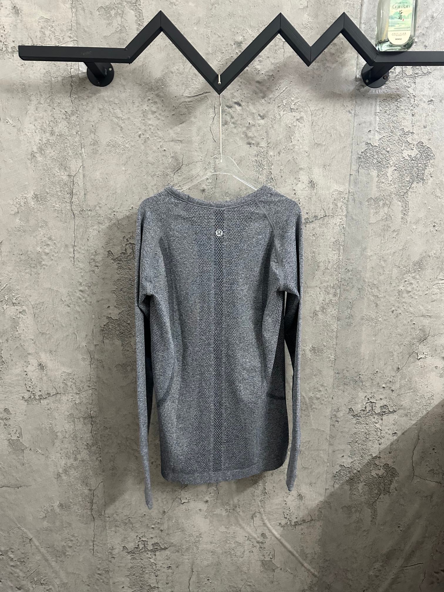 Heather gray long-sleeve knit top, back view with buttoned neckline detail