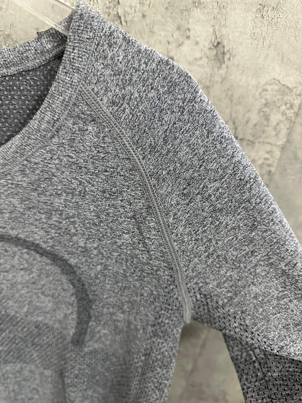 Heather gray long-sleeve knit top, close-up of front seam and stitched pattern