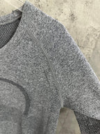 Heather gray long-sleeve knit top, close-up of front seam and stitched pattern