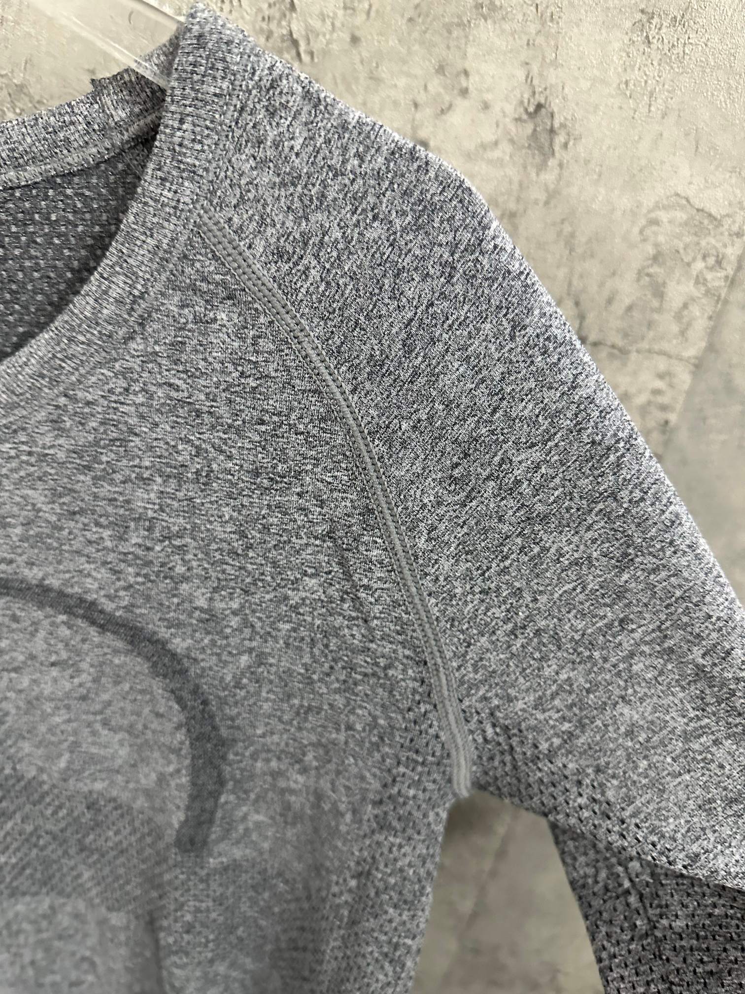 Heather gray long-sleeve knit top, close-up of front seam and stitched pattern