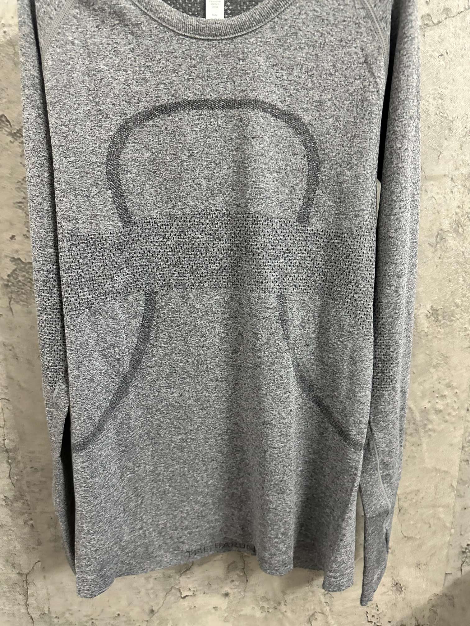Close-up of heather gray long-sleeve knit top with large abstract horse graphic