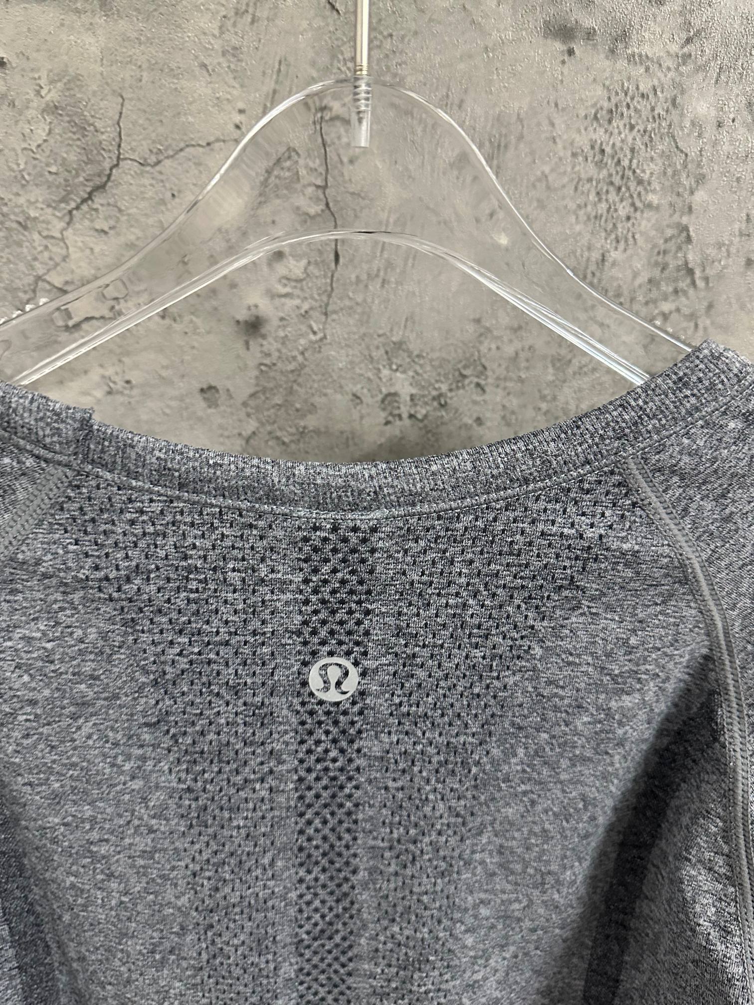 Back of heather gray long-sleeve knit top with small circular logo at center