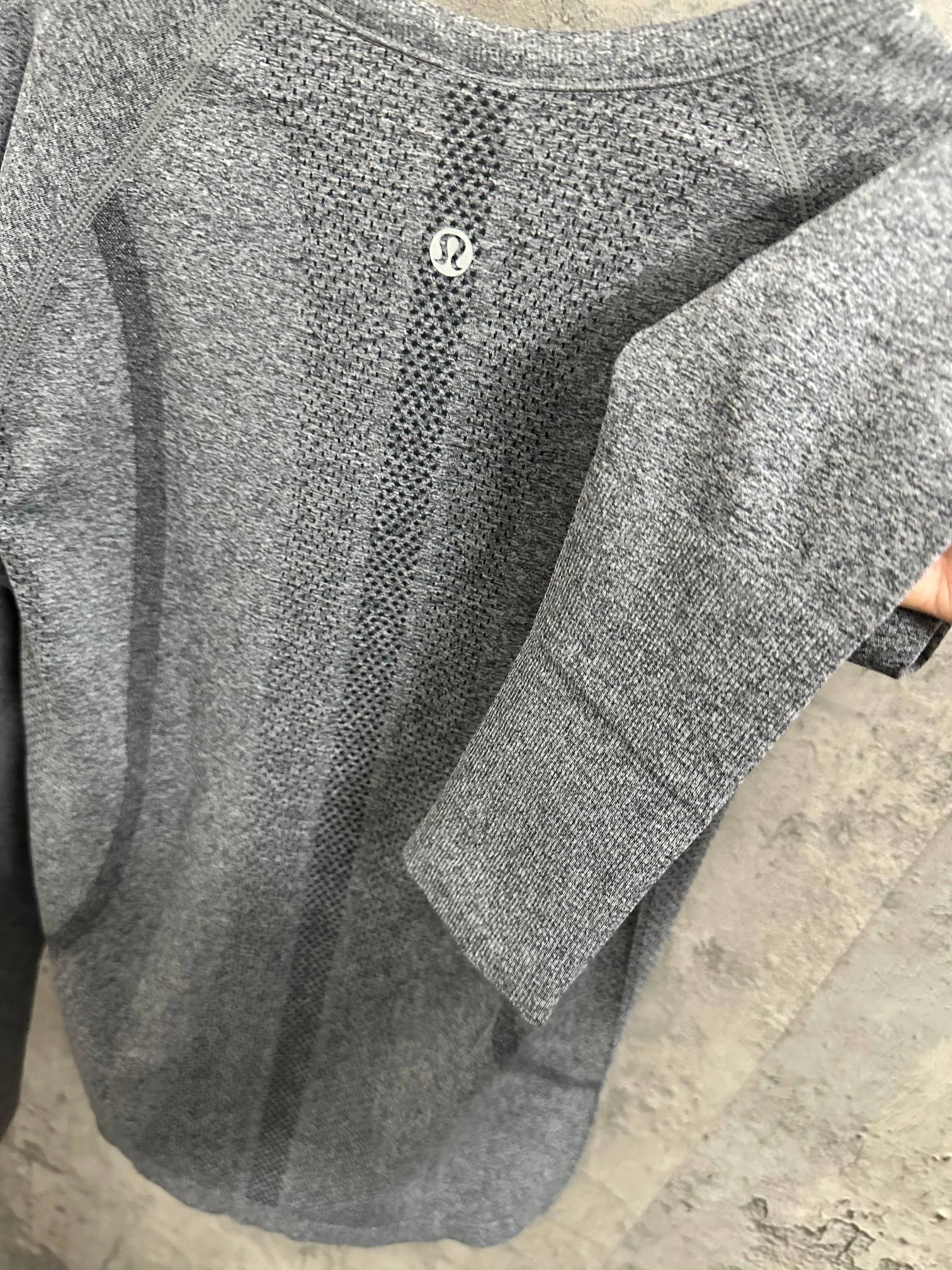 Heather gray long-sleeve knit top, angled view with textured fabric and logo
