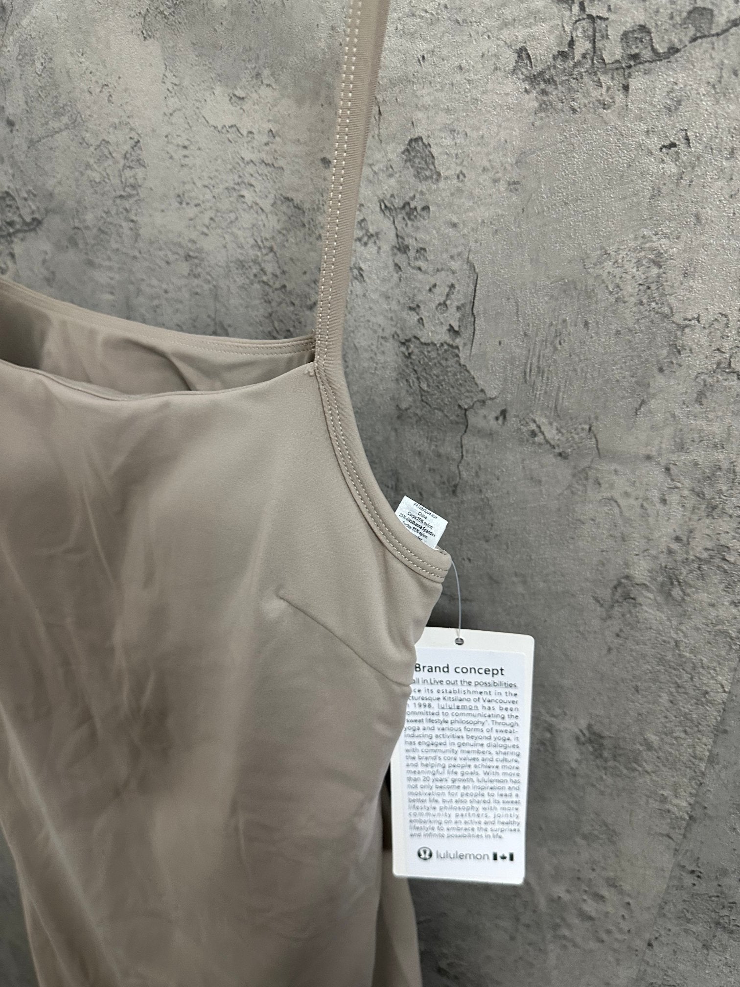 Light beige scoop-neck romper with thin straps and attached product tags