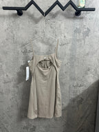 Light beige romper with thin straps, gathered waist seam, and attached tags