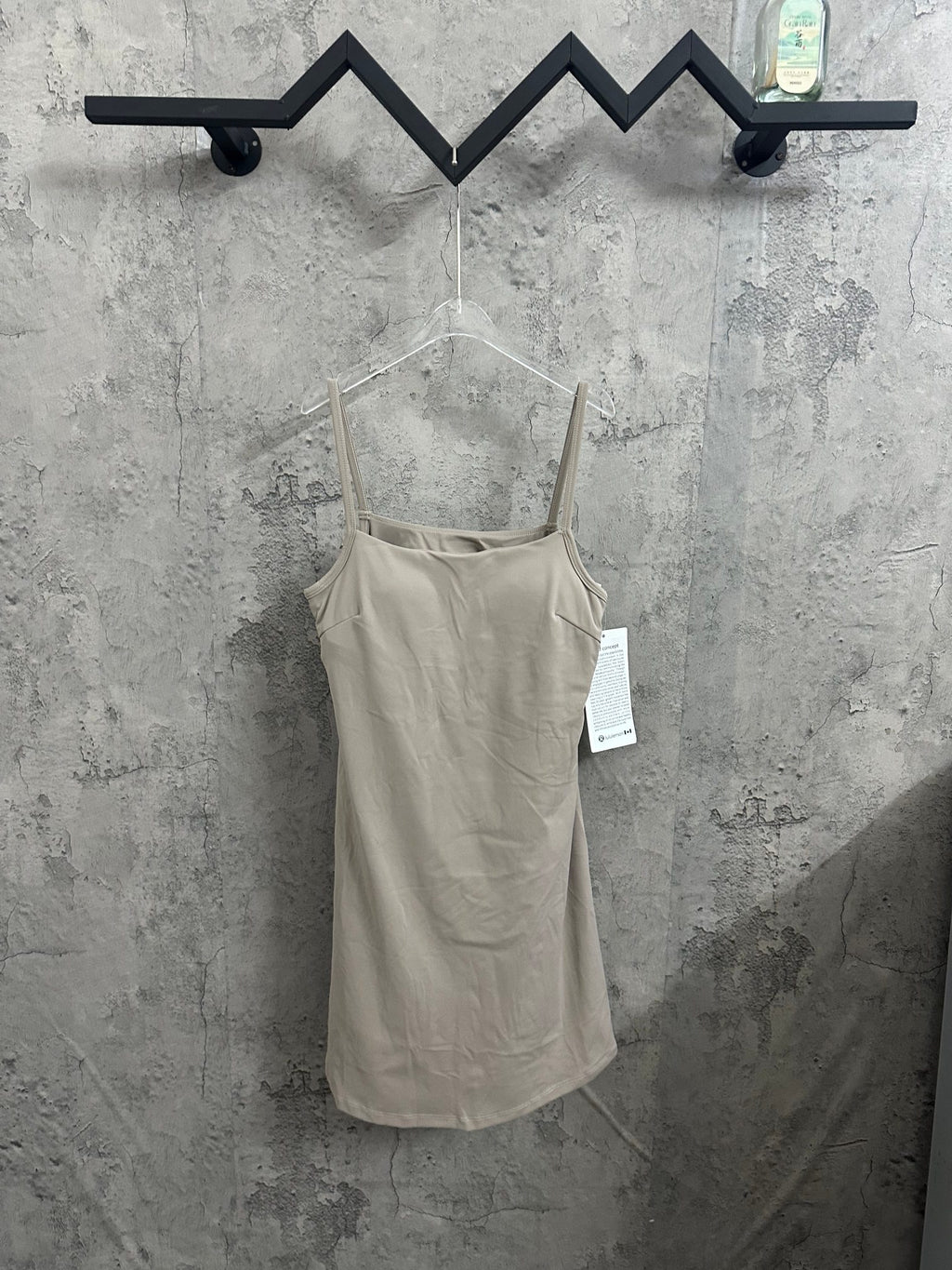 Light beige spaghetti-strap romper with scoop neckline and attached tags