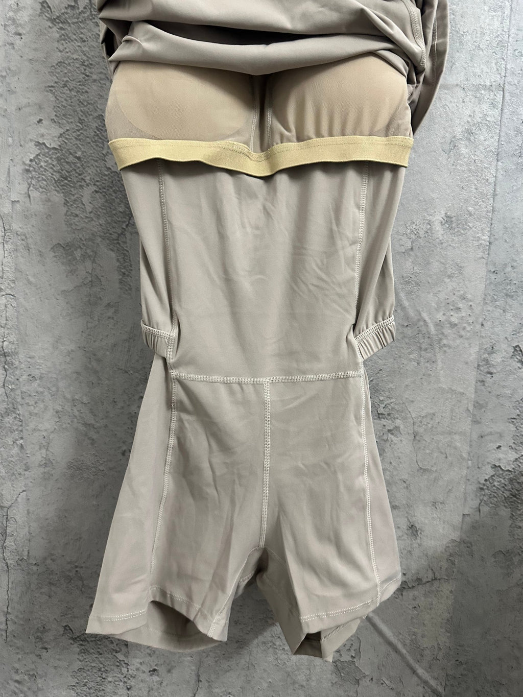 Light beige romper with ruched waist detail and short covered legs