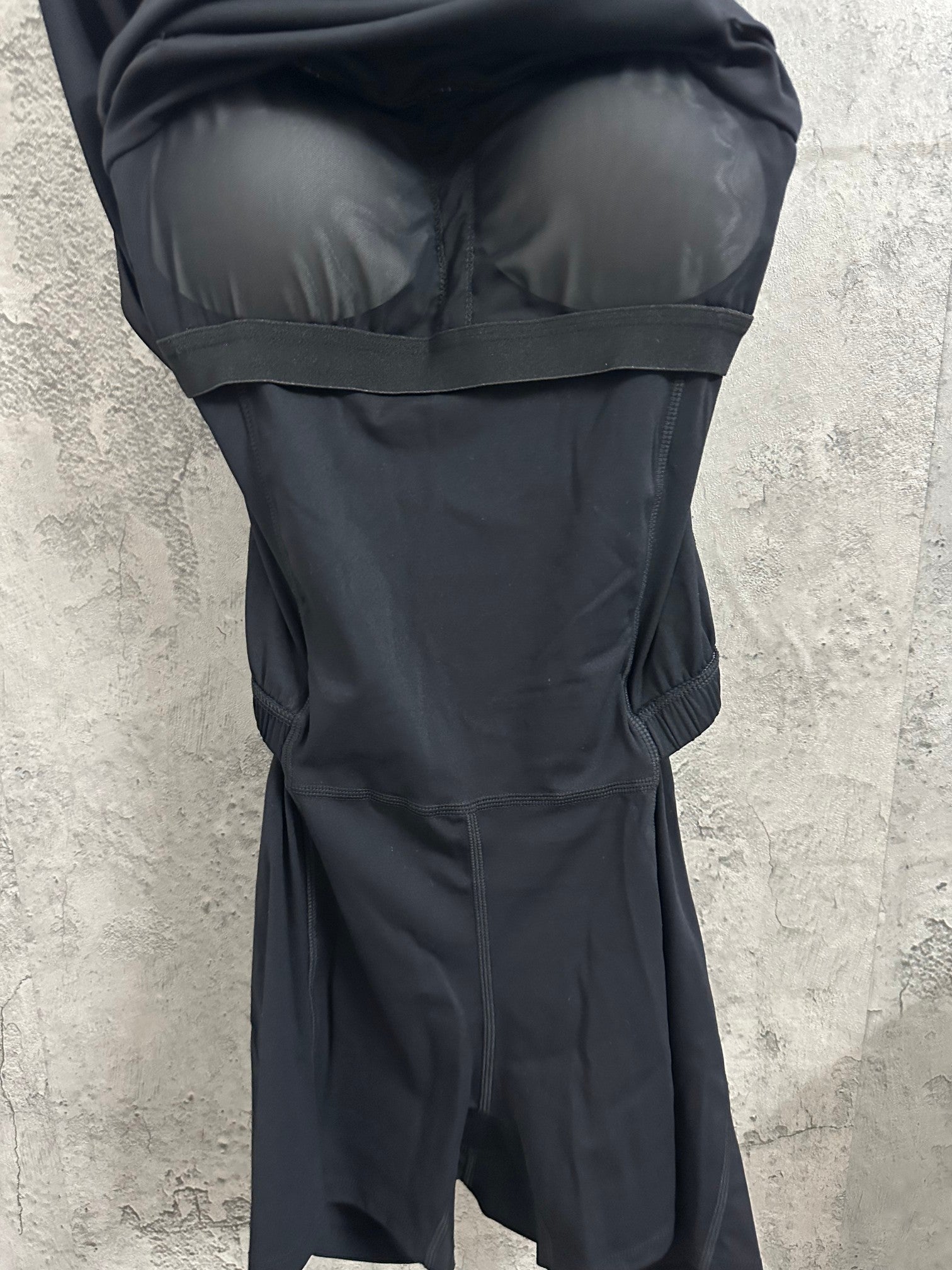Black dress close-up of bust and waistband with gathered skirt section.