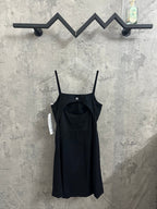 Black spaghetti-strap dress with square neckline and slightly flared skirt on hanger.