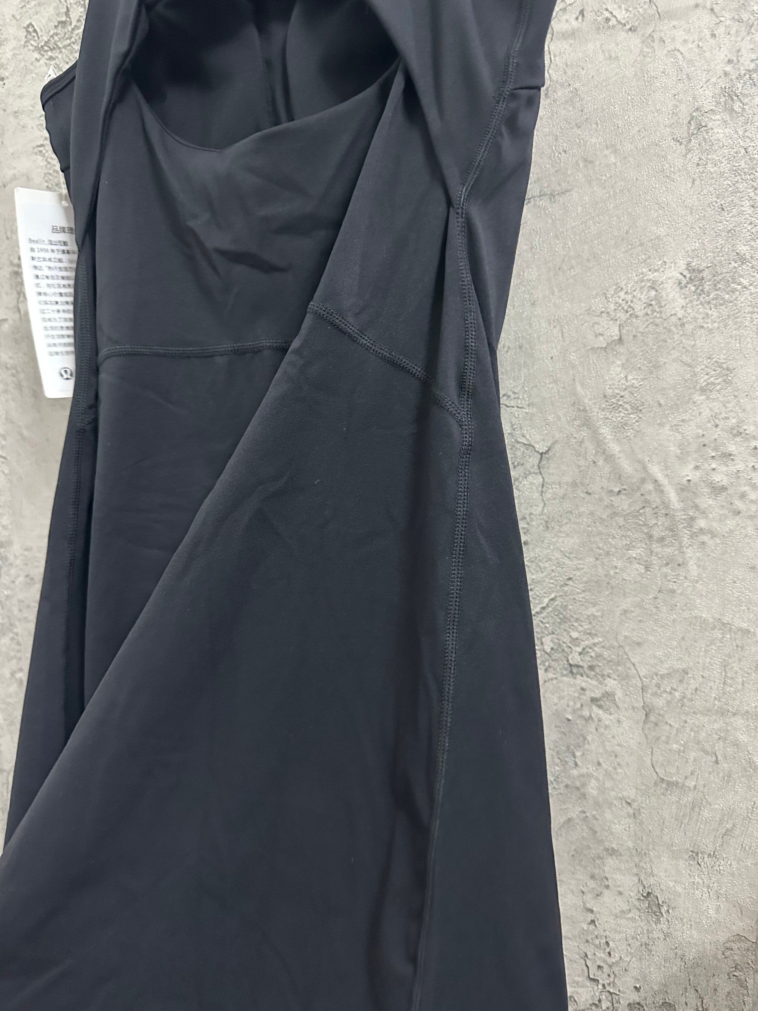 Black sleeveless dress with seam detailing and draped bodice