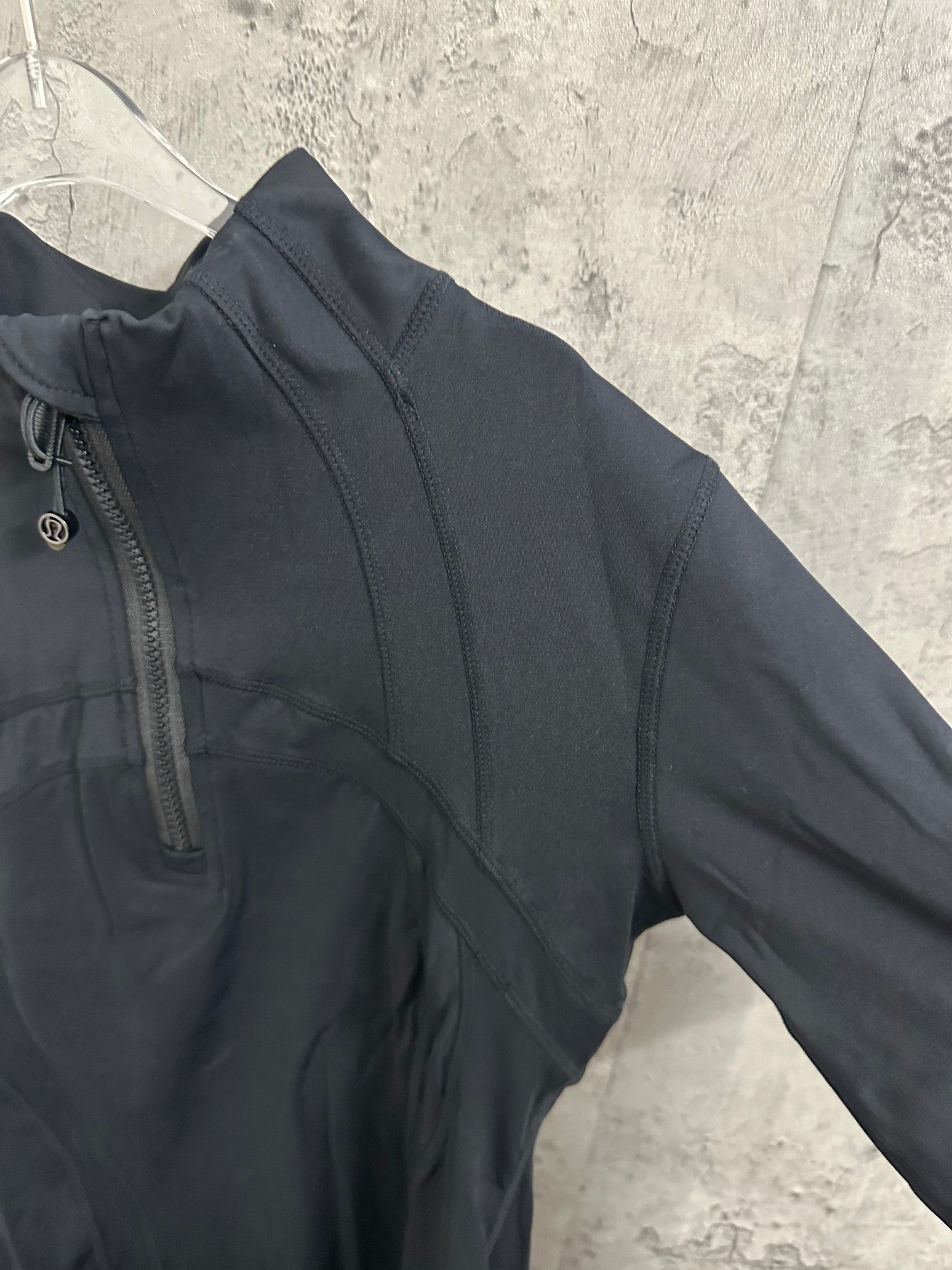 Dark long-sleeve jacket sleeve with side seam and curved chest panel