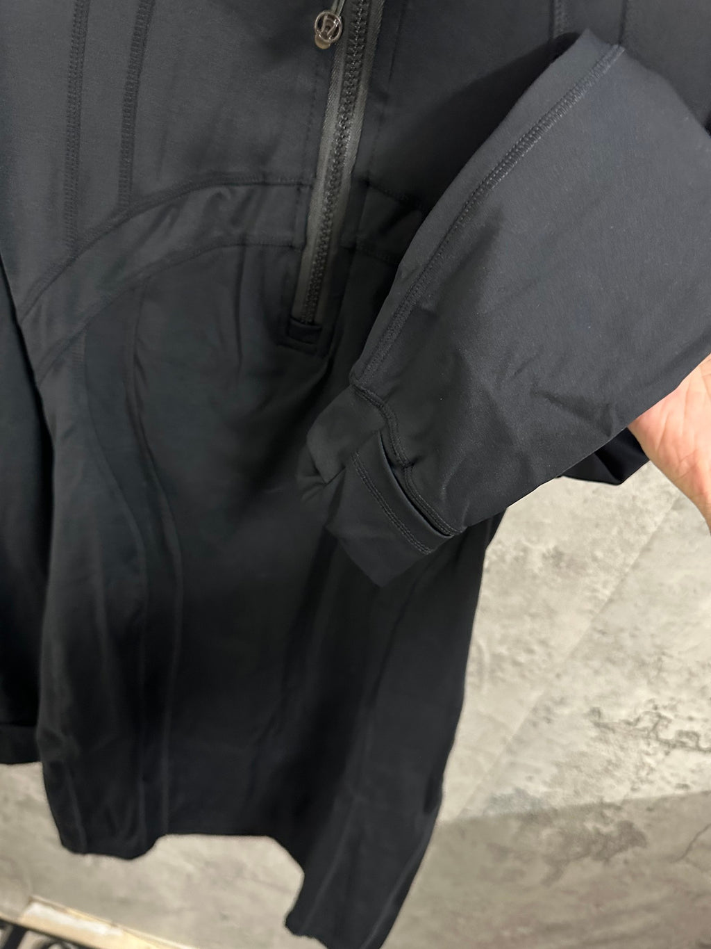Dark jacket close-up of sleeve cuff and side seam detail