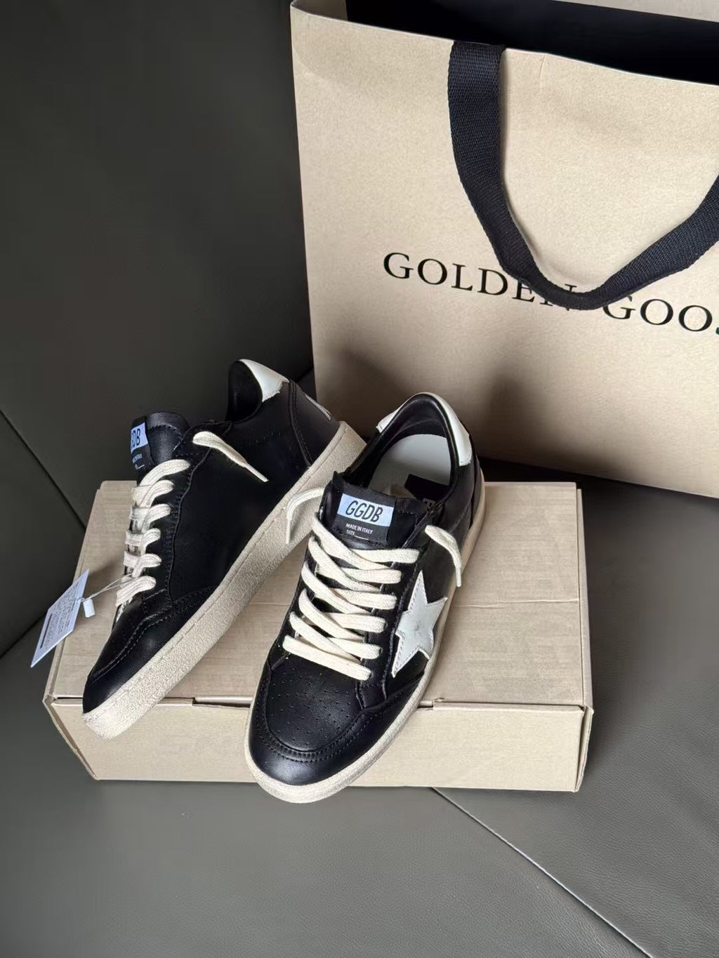 Black low-top sneakers with white star patches and white lace-up front