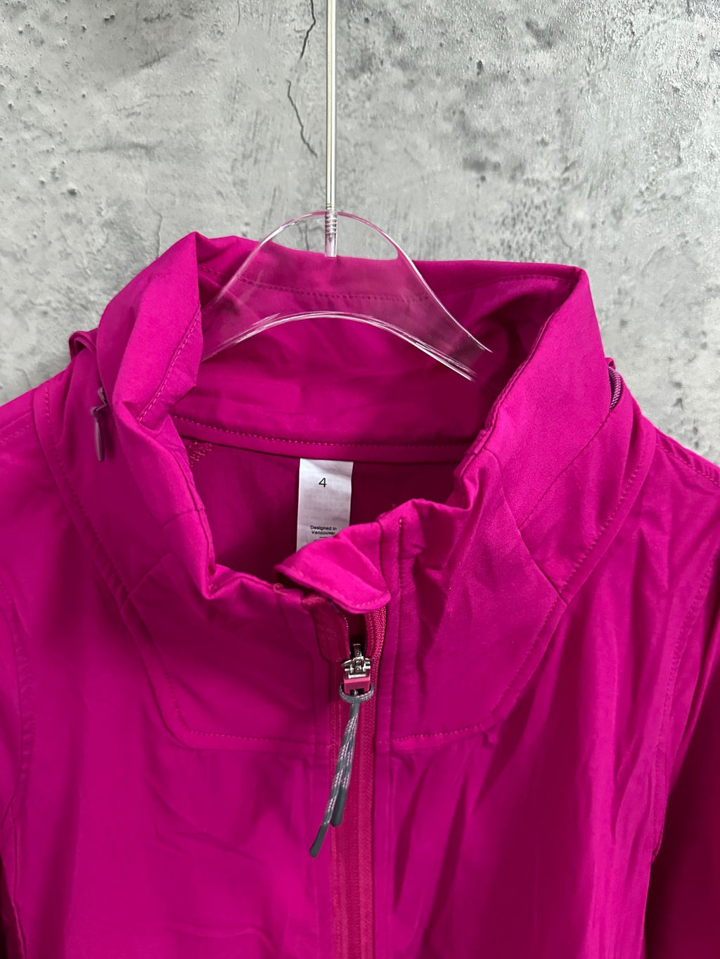 Fuchsia hooded jacket with front zipper and visible neck tag