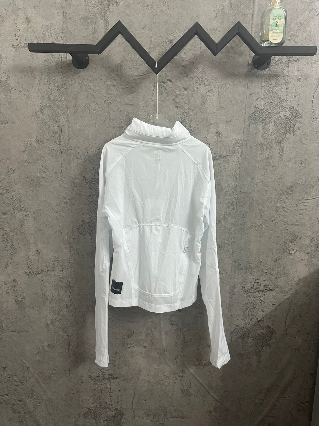 White lightweight jacket with high neck, front zipper, and hooded collar