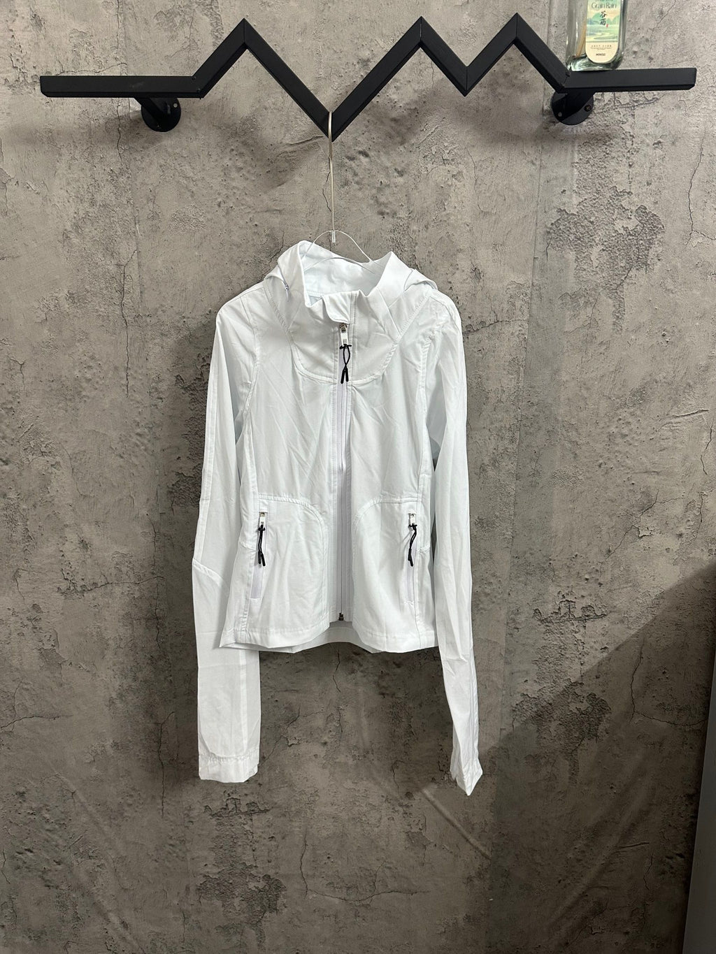 White zip-up jacket with drawstring hood and stand collar, front zipper