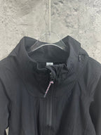 Black hooded jacket chest close-up with hidden zipper and drawstring pull