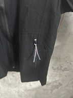 Black hooded jacket sleeve and side zipper pocket detail with logo tab