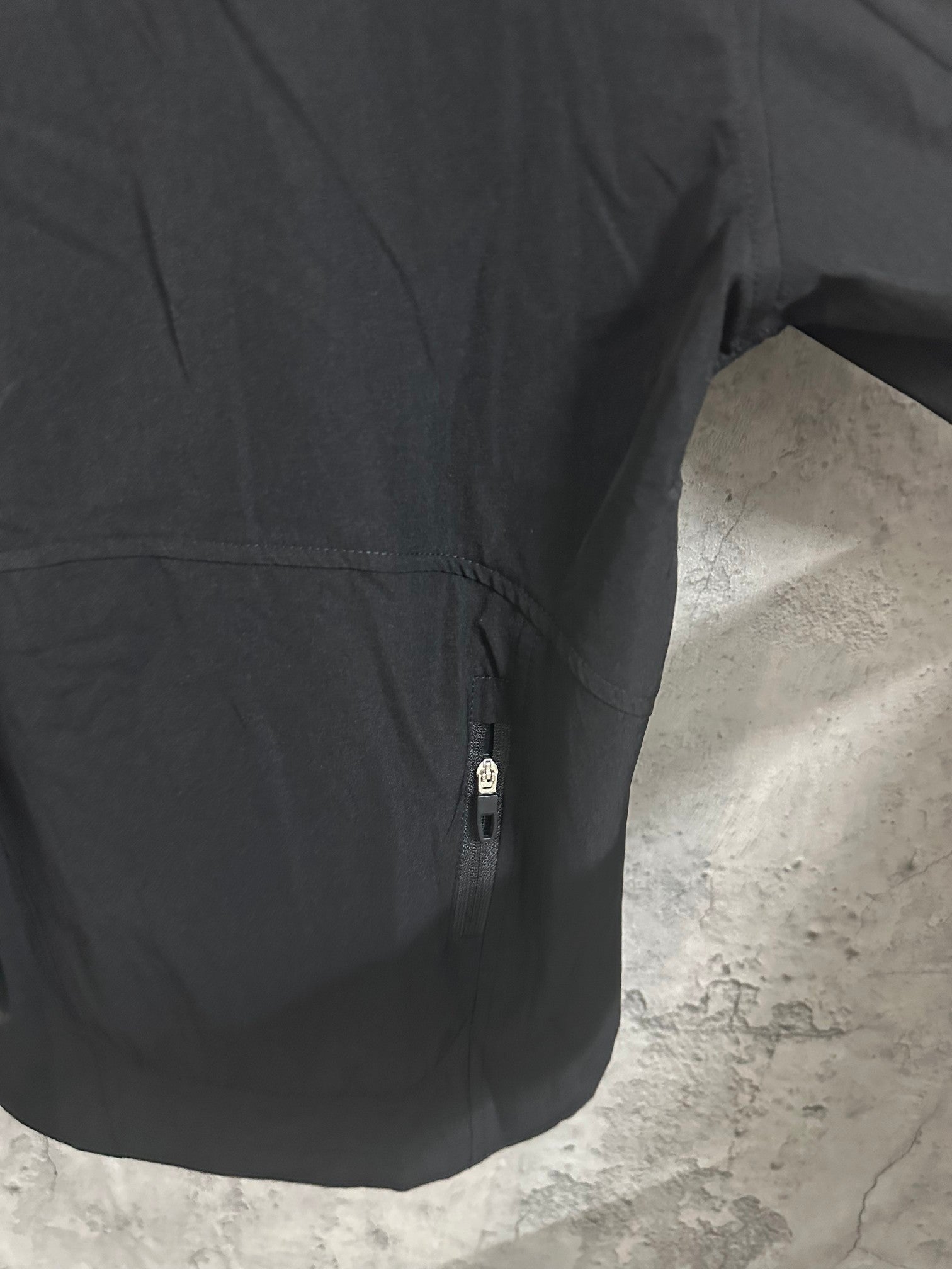 Black hooded jacket side seam and concealed zipper pocket