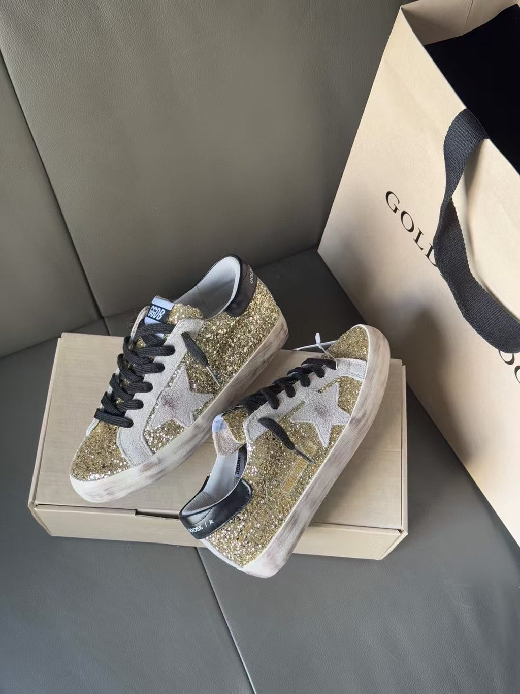 Golden Goose low-top sneakers with gold glitter overlays and black laces, white sole