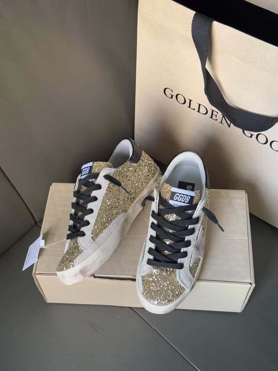 Golden Goose sneakers pair with gold glitter side panels and black lace-up front