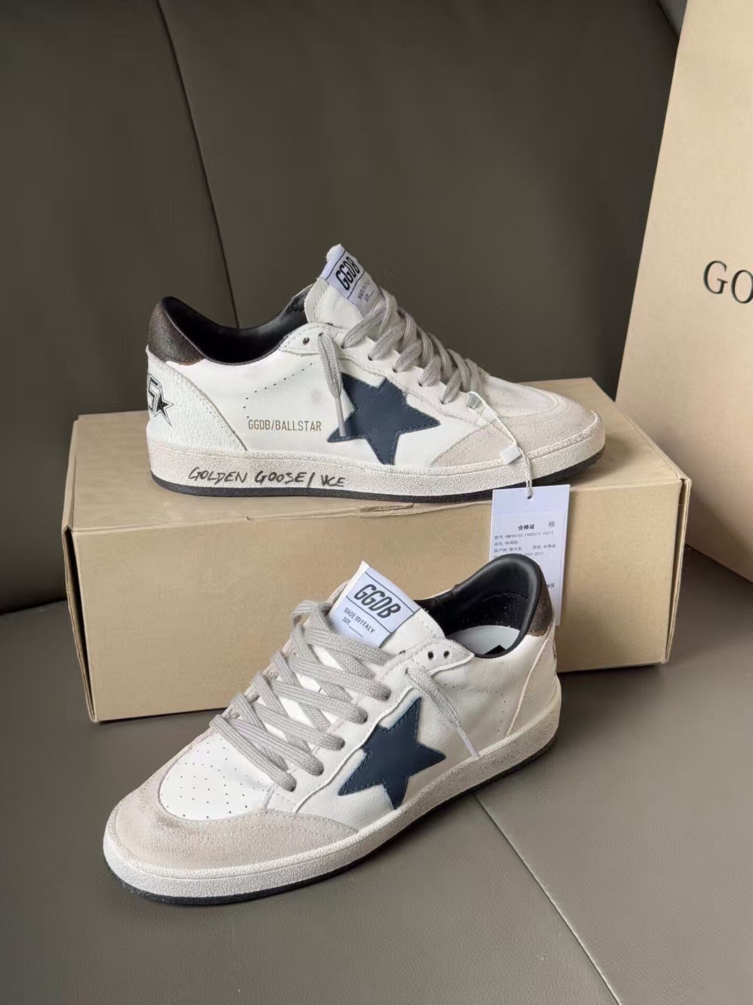 Pair of white low-top sneakers with blue star patches, gray sole, lace-up design