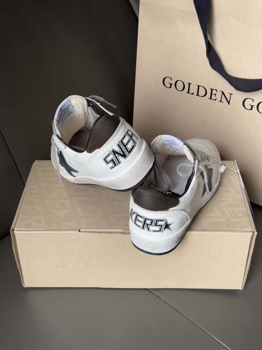White sneakers with gray heel counter and black heel patch, lace-up on shoebox