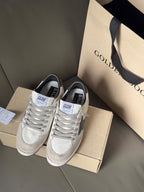 White lace-up sneakers with blue star side panels, perforated toe, on shoebox