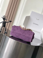 Purple Chanel quilted mini shoulder bag on display, gold chain strap
