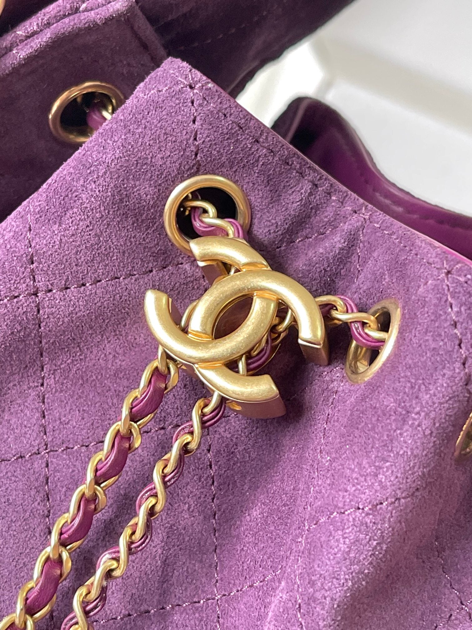 Purple bag flap with gold-tone chain hardware and ring detail