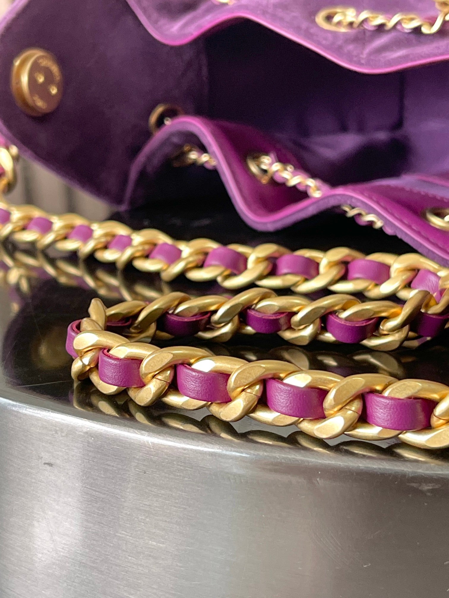 Gold-and-purple chain strap detail on purple Chanel bag