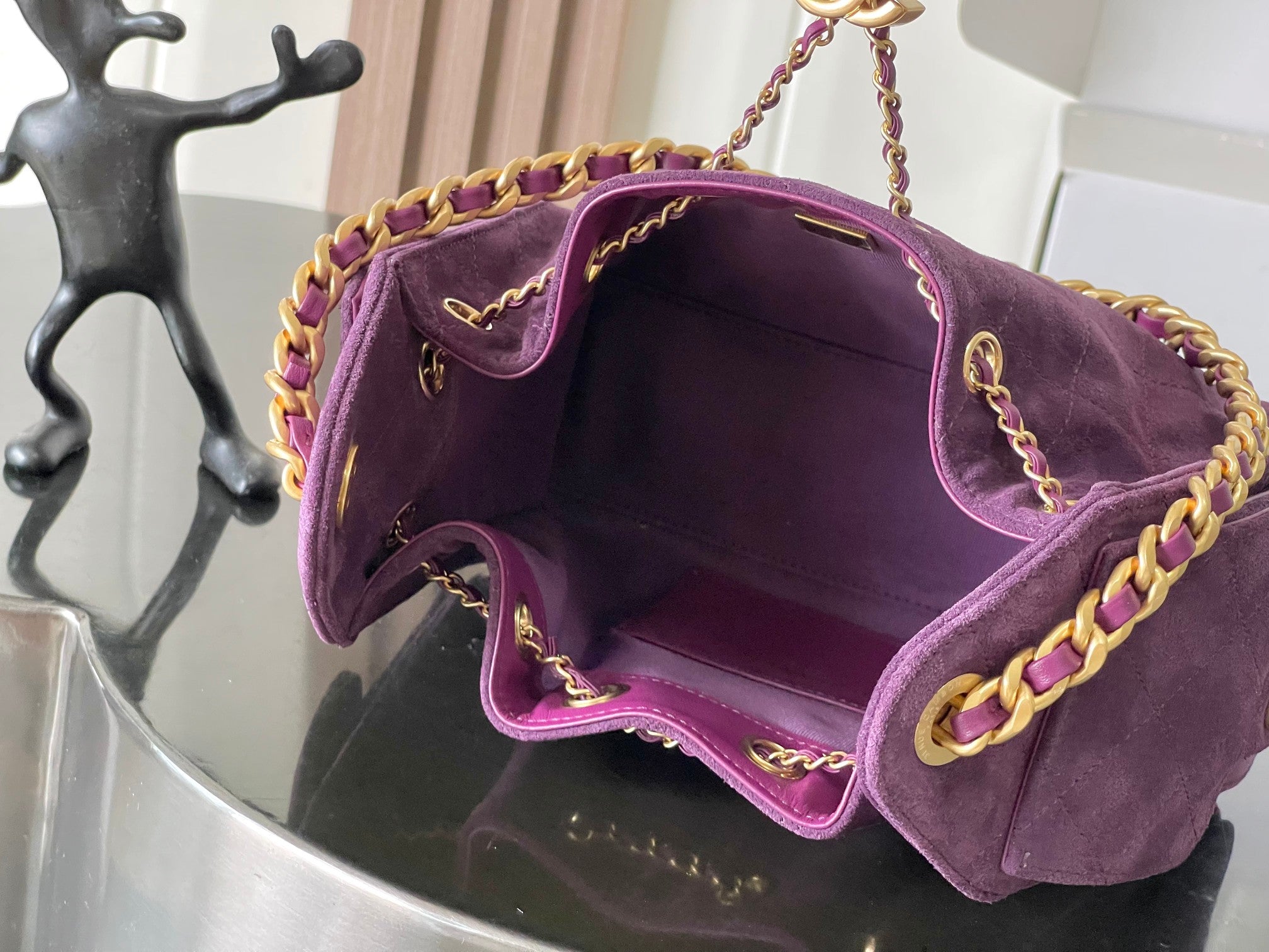 Open purple Chanel bag interior with gold chain shoulder strap