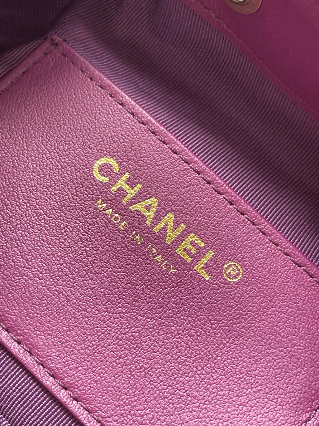 Purple Chanel leather patch with gold logo text on bag panel