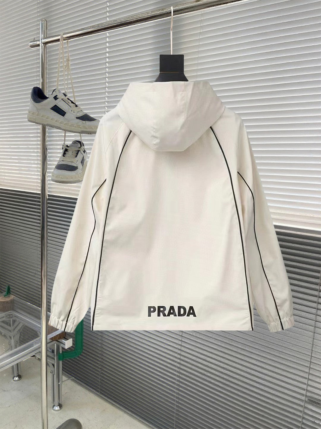 White hooded jacket back with PRADA lettering and black trim accents